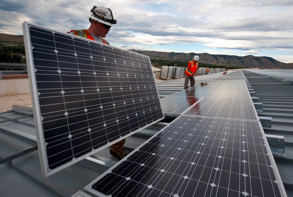 Deux ouvriers installent des panneaux solaires