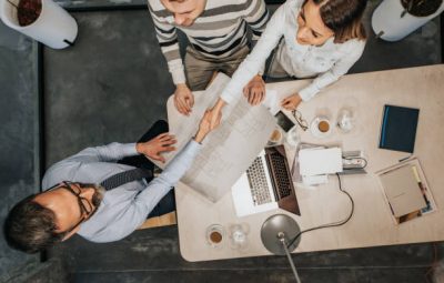 Trois personnes qui signent l'ouverture d'un commerce associé