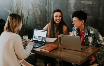 collègues assis devant leur ordinateur portable et riant ensemble